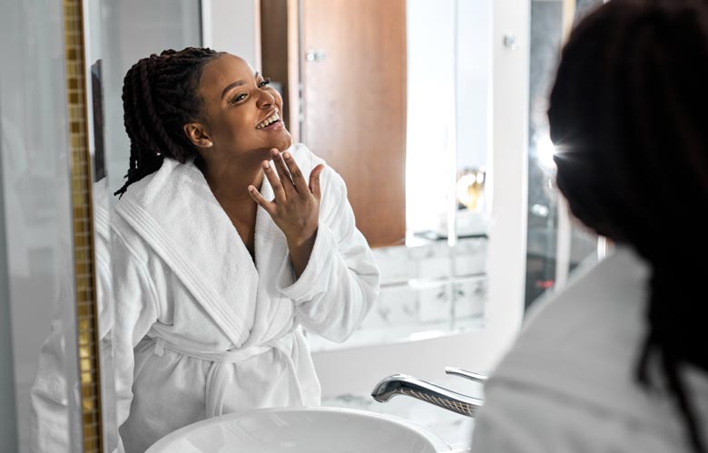 woman smiling and looking in mirror