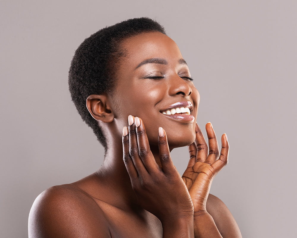 woman smiling with hands on her face