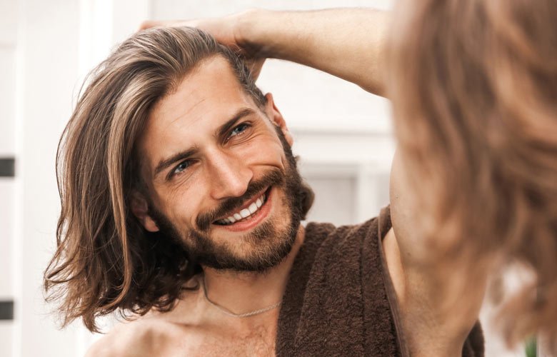 man smiling and looking in mirror