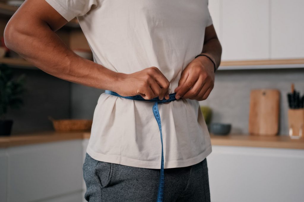 man measuring waist