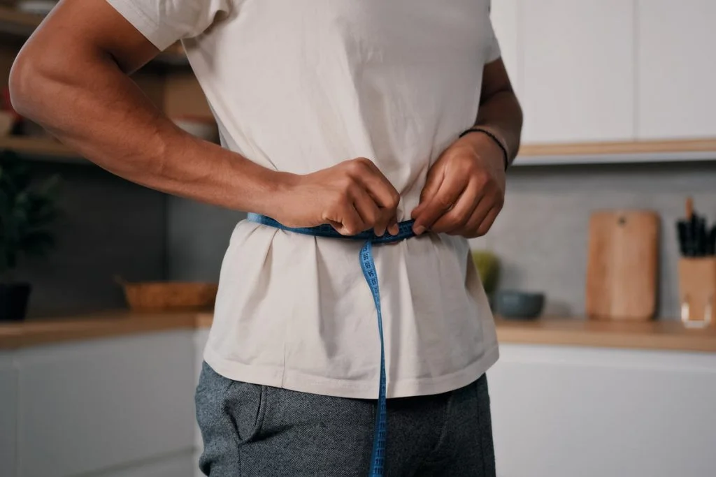man measuring waist