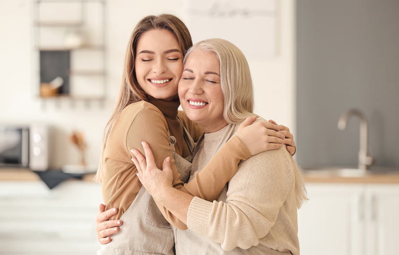 two women smiling and hugging