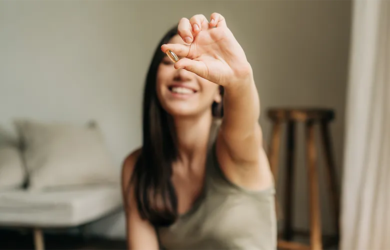 woman holding supplement capsule